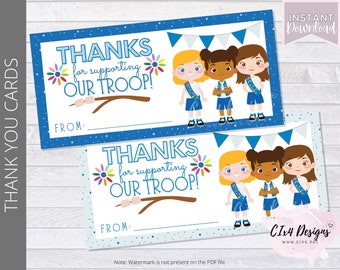 Può includere: Due biglietti di ringraziamento stampabili con sfondo blu e bianco. I biglietti presentano una grafica di tre ragazze in uniforme di Girl Scout e il testo "GRAZIE per aver sostenuto LA NOSTRA TRUPPA!"
