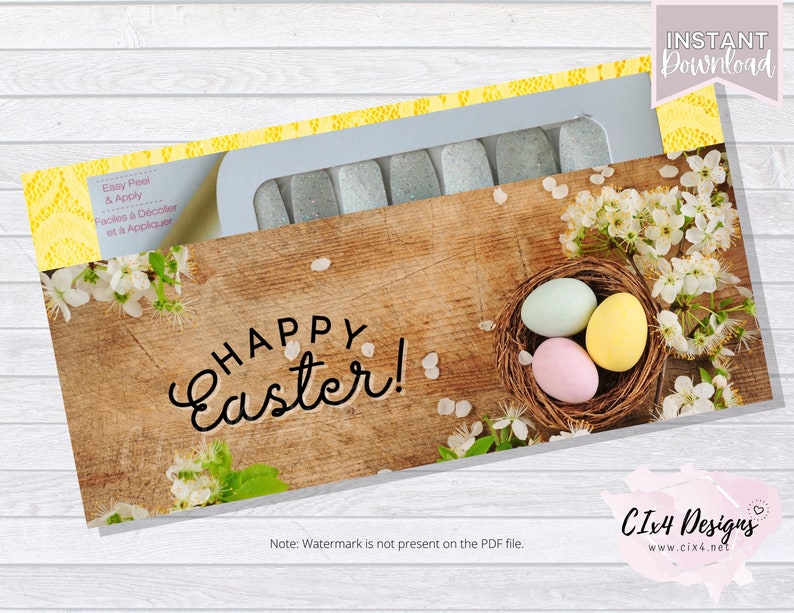 May include: A set of nail wraps with a glittery finish. The design features a wooden background with a nest of Easter eggs and white flowers. The text "Happy Easter!" is written in a cursive font.