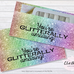 May include: Two rainbow glitter envelopes with the text "You're GLITTERALLY amazing!" printed on them. The envelopes are designed for nail polish strips.