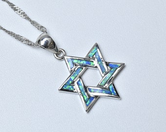 May include: A silver chain necklace with a pendant in the shape of a six-pointed star, also known as the Star of David. The star is made of silver and has a blue and green opal inlay.