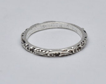 May include: A silver ring with a delicate floral design. The ring is thin and has a smooth finish.