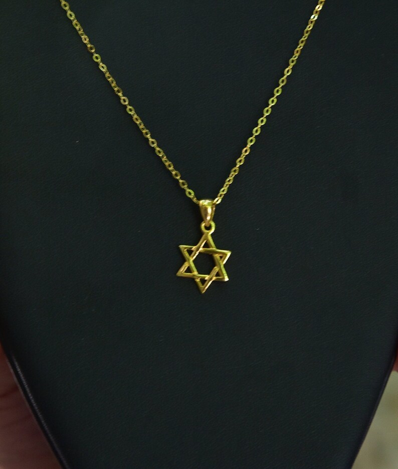 May include: A gold chain necklace with a Star of David pendant.