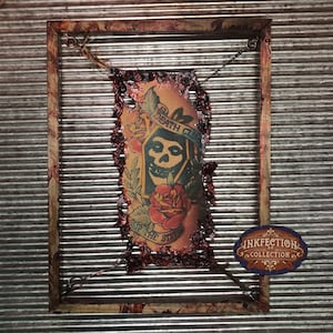 May include: A framed piece of art featuring a ripped piece of skin with a tattoo of a skull wearing a hooded robe with the words "Death Club" and "Up the Sleeve" visible. The frame is distressed and has a red stain around the edges. The artwork is labeled "Inkfection Collection".