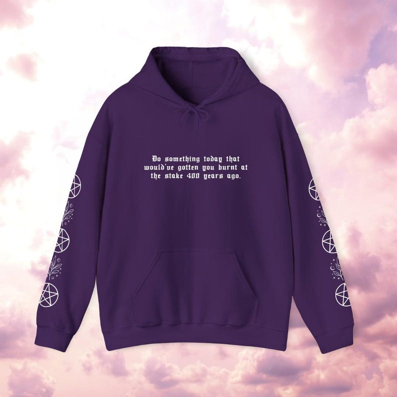 Peut inclure: Un sweat &agrave; capuche violet avec une poche avant et une capuche &agrave; cordon. Le texte "Do something today that would've gotten you burnt at the stake 400 years ago" est imprim&eacute; sur le devant. Des pentagrammes blancs et des motifs floraux ornent les manches.