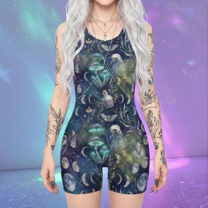 May include: A sleeveless, dark blue romper with a celestial and botanical print. The design features moons, mushrooms, butterflies, and potion bottles. The garment has a scoop neckline and a fitted silhouette, perfect for a unique and stylish look.