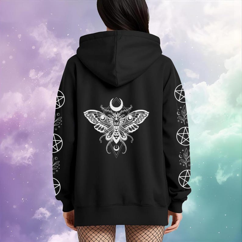 Peut inclure: Sweat &agrave; capuche noir avec un motif de papillon blanc d&eacute;taill&eacute; dans le dos, orn&eacute; d'un croissant de lune et de motifs g&eacute;om&eacute;triques. Les manches pr&eacute;sentent des pentagrammes blancs et des motifs botaniques. Le sweat &agrave; capuche est de couleur fonc&eacute;e.