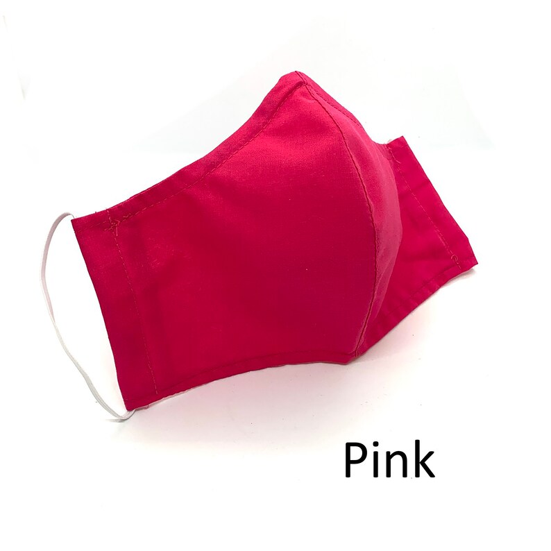 May include: A pink fabric face mask with white elastic ear loops.