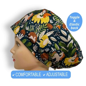 May include: A dark green scrub hat with a whimsical print featuring unicorns, flowers, and woodland creatures. The hat has an adjustable toggle and elastic back.  "COMFORTABLE" and "ADJUSTABLE" are printed on the bottom of the image.