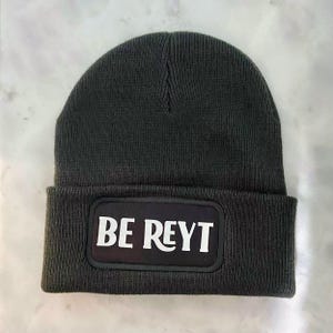 May include: A dark grey beanie with a black patch that says "BE REYT" in white letters.