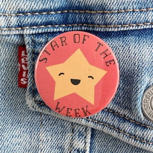 May include: A red and yellow button with the text "Star of the Week" and a smiling yellow star in the centre.