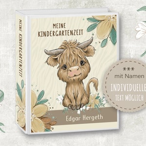 Könnte beinhalten: Ein weißer Ordner mit braunem und grünem Blumendesign. Der Ordner hat den Text "Meine Kindergartenzeit" und "Edgar Hergeth" auf der Vorderseite. Eine süße Comic-Highland-Kuh befindet sich in der Mitte des Ordners. Der Text "*** mit Namen INDIVIDUELLER TEXT MÖGLICH" befindet sich auf einem braunen Kreis.