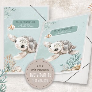 Könnte beinhalten: Zwei blaue und weiße Ordner mit einer Aquarell-Illustration einer Meeresschildkröte und dem Text "Meine Kunstwerke Arielle Ocean" auf jedem. Die Ordner haben einen weißen Rand und ein weißes Etikett mit dem Text "*** mit Namen INDIVIDUELLER TEXT MÖGLICH" unten.