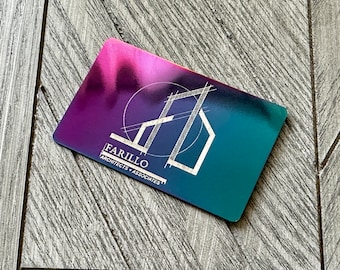 May include: A rectangular business card with a metallic gradient finish transitioning from purple to teal. The card features a white line-art logo of a building structure inside a circle, with the text FARILLO ARCHITECTS + ASSOCIATES below.