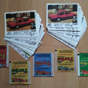 May include: A stack of trading cards featuring a red Opel Ascona car with the text "Turbo" on the front.  The cards are from a set of 50.  There are also three packs of chewing gum with the text "Turbo" and a car on the front.