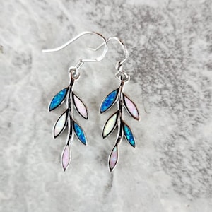 May include: Silver earrings with a delicate branch design featuring blue, pink, and white opal stones.