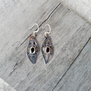 Sterling Silver & Garnet Earrings In An Intricate Silver Cutout Design