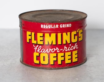 May include: A vintage red metal coffee can with the words "Fleming's flavor-rich Coffee" in yellow lettering and "Regular Grind" in white lettering.