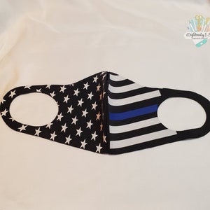 Op de afbeelding: Zwart gezichtsmasker met een blauwe lijn en een Amerikaans vlagontwerp.