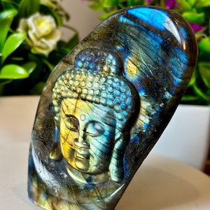 May include: A white ceramic mug with a black handle and the text "But first, coffee" in a black, handwritten-style font. The mug is on a white surface.