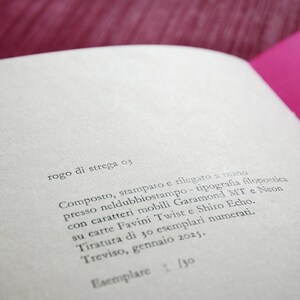May include: A close-up of a book's title page with the text "rogo di strega 03" printed in black ink. The page also includes details about the book's printing and binding, including the types of paper and fonts used.