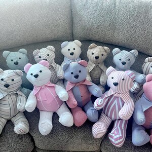May include: A collection of eleven handmade teddy bears crafted from various patterned and solid-colored fabrics, including stripes, plaids, and checks in shades of blue, pink, white, and tan, each featuring dark button eyes and stitched noses.