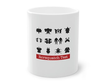 May include: White ceramic mug featuring a series of black inkblot designs. The mug has a red banner with the text "Rorsquatch Test" printed in white. A unique and quirky gift idea.
