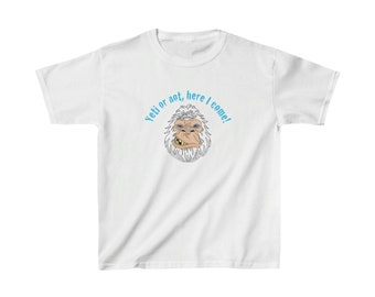 May include: White t-shirt featuring a cartoon yeti face with a toothy grin. The text "Yeti or not, here I come!" arches above the yeti's head in light blue. The shirt is a casual wear item.
