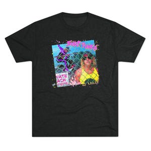 May include: Dark gray t-shirt featuring a graphic design with the text "Surf Punks" in pink and green. The design includes an image of a person behind a chain-link fence, with the words "Private Beach" and "Passing Beyond" in the design.