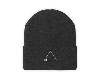 May include: Dark gray beanie with a white triangle graphic. Inside the triangle is a small mountain scene. The beanie is a warm, comfortable accessory for cold weather. The hat is a versatile item for outdoor activities.