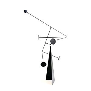 May include: A black metal kinetic sculpture featuring a tall, triangular pyramid base supporting a series of thin, branching arms. Several flat, circular discs are attached to the ends of these arms, creating a balanced, multi-tiered structure.