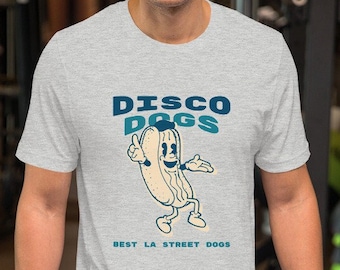 May include: A heather grey t-shirt with a cartoon hot dog wearing a chef's hat and dancing. The text "DISCO DOGS" is above the hot dog and "BEST LA STREET DOGS" is below the hot dog.