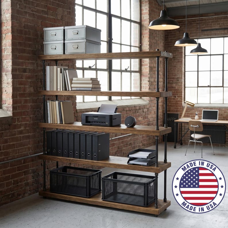 May include: A five-tier industrial shelving unit with thick wooden shelves and dark metal pipe supports. The shelves hold grey storage boxes, books, a black printer, black binders, and black wire mesh baskets. A Made in USA circular logo is visible.