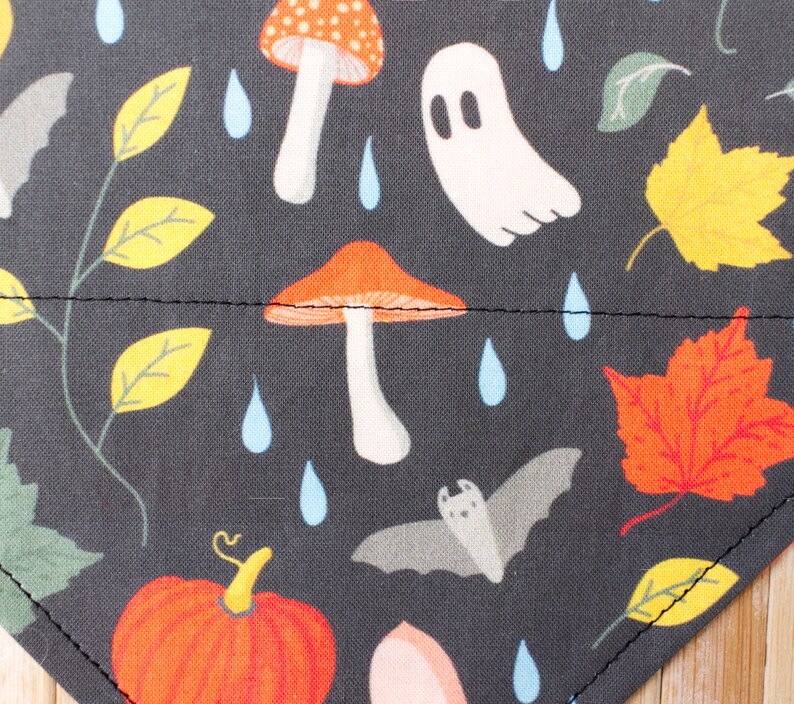 Peut inclure: Tissu noir avec un motif r&eacute;p&eacute;t&eacute; de champignons orange et blancs, de chauves-souris grises, de fant&ocirc;mes blancs, de feuilles orange et jaunes et de gouttes de pluie bleues.
