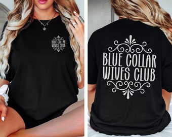 Może przedstawiać: Czarny T-shirt z napisem "Blue Collar Wives Club" w kolorze białym z tyłu i mniejszą wersją napisu na lewej piersi z przodu.