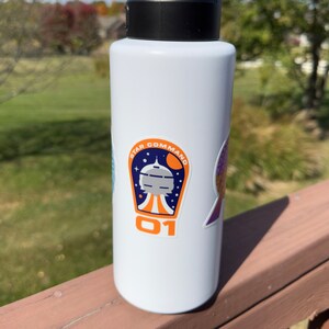 May include: White water bottle with a blue, orange, and white sticker that says "Star Command 01".