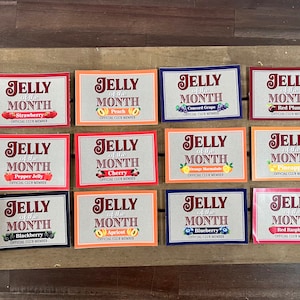 May include: Twelve colorful cards with the text "Jelly of the Month" and a different fruit or flavor listed on each card. The cards are arranged in four rows of three cards each.
