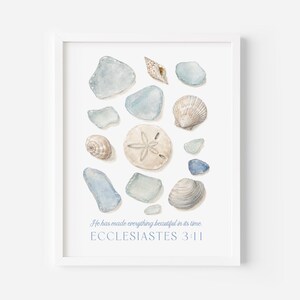 May include: A framed wall art print featuring a watercolor illustration of various sea glass pieces, seashells, and a sand dollar. The text below reads: He has made everything beautiful in its time. ECCLESIASTES 3:11. The design is set against a white background.
