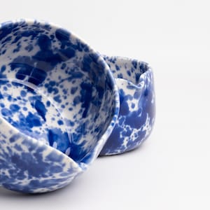 K&ouml;nnte beinhalten: Zwei Keramikschalen mit einem blauen und wei&szlig;en Spritzmuster. Die Schalen sind ineinander verschachtelt.