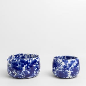 K&ouml;nnte beinhalten: Zwei Keramikschalen mit einem blauen und wei&szlig;en gesprenkelten &Uuml;berzug. Die gr&ouml;&szlig;ere Schale hat einen Ausgie&szlig;er.