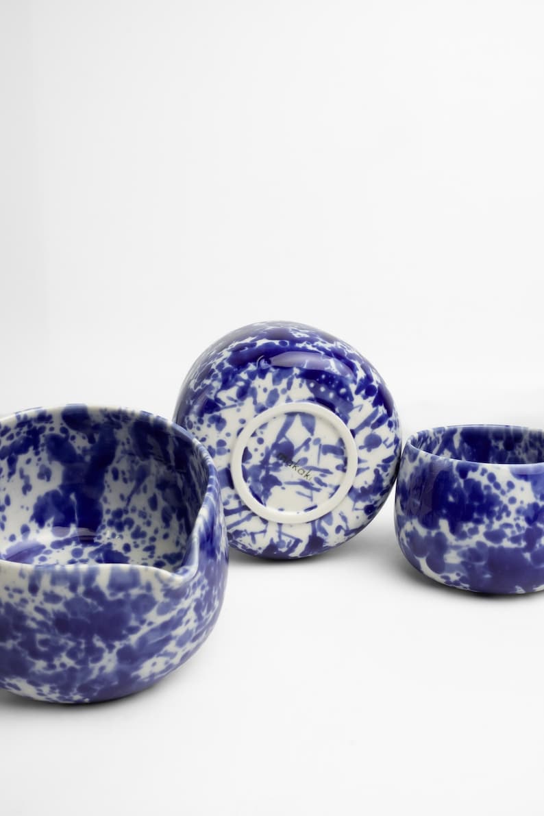 K&ouml;nnte beinhalten: Drei Keramik-Schalen mit einem blauen und wei&szlig;en Spritzmuster. Die Schalen sind in verschiedenen Gr&ouml;&szlig;en und Formen. Der Boden einer Schale tr&auml;gt die Aufschrift "Noroki".