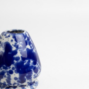 K&ouml;nnte beinhalten: Eine blaue und wei&szlig;e Keramikvase mit einem gesprenkelten Design. Die Vase ist birnenf&ouml;rmig und hat eine breite &Ouml;ffnung.