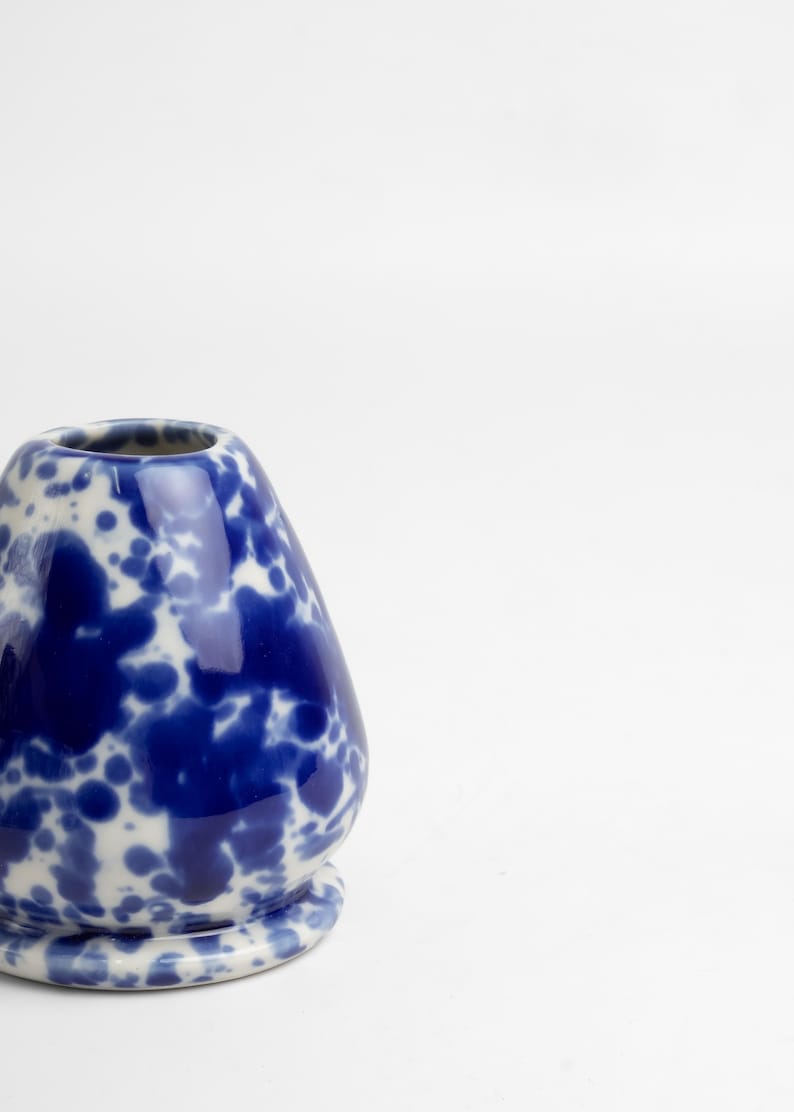 K&ouml;nnte beinhalten: Eine blaue und wei&szlig;e Keramikvase mit einem gesprenkelten Design. Die Vase ist birnenf&ouml;rmig und hat eine breite &Ouml;ffnung.