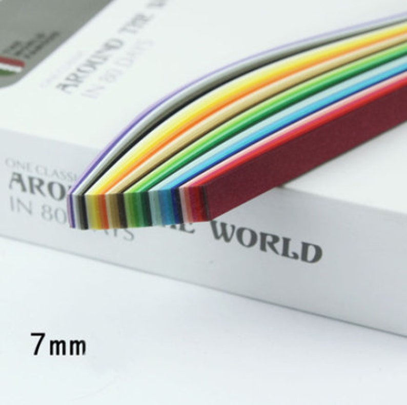 May include: A pack of 7 mm wide quilling paper strips in a rainbow of colors. The paper is arranged in a curved shape, with the red strip on top and the purple strip on the bottom.