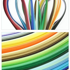 May include: Assortment of colorful paper strips, arranged in a fan shape and stacked in a rainbow pattern. The paper strips are thin and delicate, perfect for crafting and paper art.