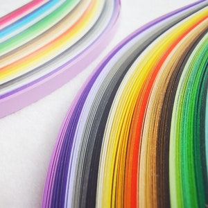 May include: A rainbow of colorful paper strips arranged in a curved pattern. The strips are layered on top of each other, creating a gradient effect. The colors range from purple to blue, green, yellow, orange, and red.
