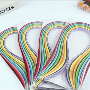 May include: A pack of rainbow colored paper strips for crafting. The strips are arranged in a rainbow pattern and are packaged in clear plastic.