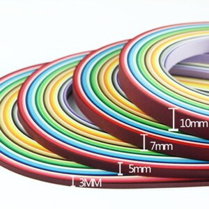 May include: Assortment of colorful paper strips in various widths, including 3mm, 5mm, 7mm, and 10mm. The strips are arranged in a rainbow pattern.
