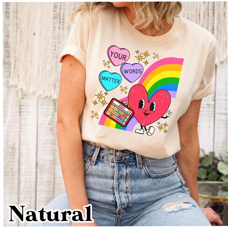 May include: A cream coloured t-shirt with a rainbow, a heart, and candy hearts that say "Your Words Matter".