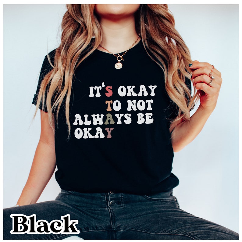 May include: Black t-shirt with the text "It's okay to not always be okay" in colorful letters.
