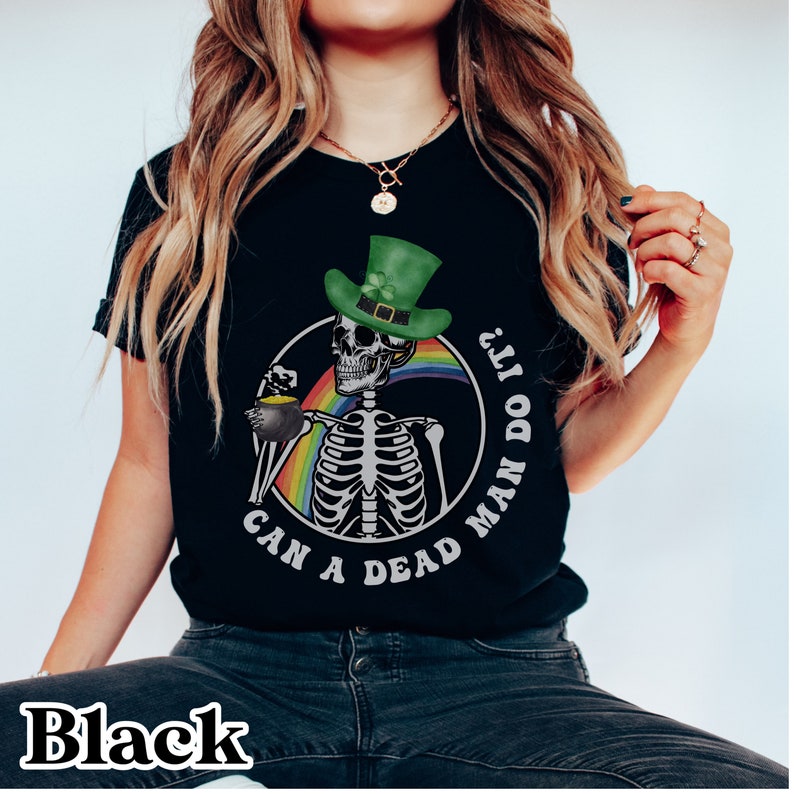 May include: Black t-shirt with a graphic of a skeleton wearing a green leprechaun hat and holding a pot of gold. The text "Can a dead man do it?" is printed around the skeleton.